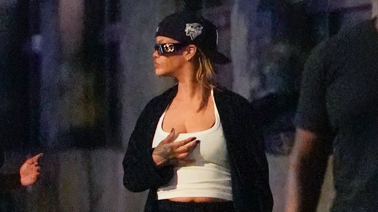 Rihanna wearing a white tank top, a black robe, black shorts, and Puma sneakers in New York City July 2024