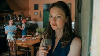 Nina looking worried as she drinks wine