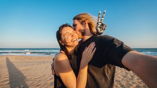 Two people hug and laugh while taking a selfie