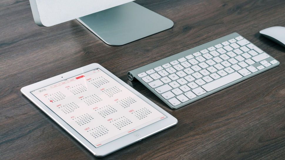 A calendar next to a desktop computer.