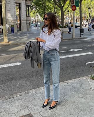 style influencer Felicia Akerstrom in a spring outfit with slingback heels, jeans, and white button-down shirt