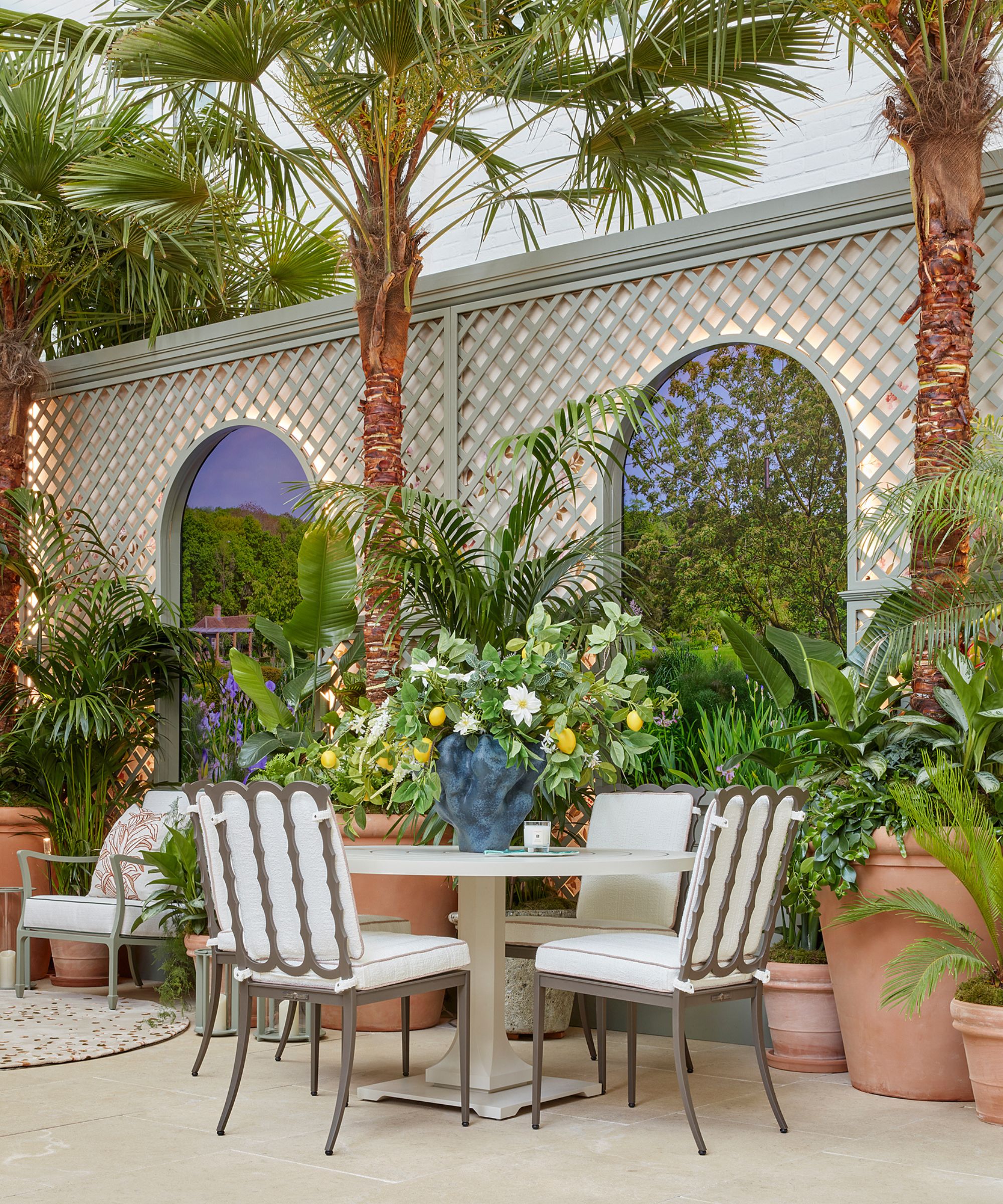 A garden terrace with large palm trees and outdoor furnishings