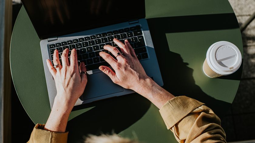 Corporate image of hands typing on a laptop keyboard in an outdoor environment, perhaps a balcony, a garden or a rooftop terrace.