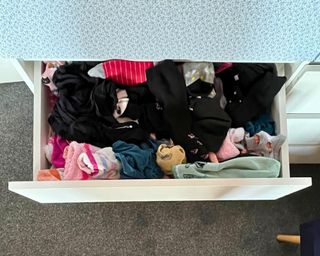 Open sock drawer showing a mess of all different colored socks and no order