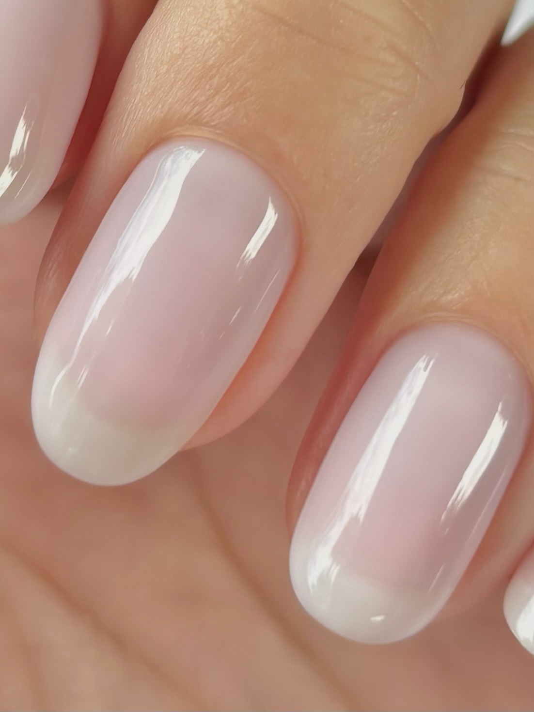 A close up of glassy, sheer pink nails