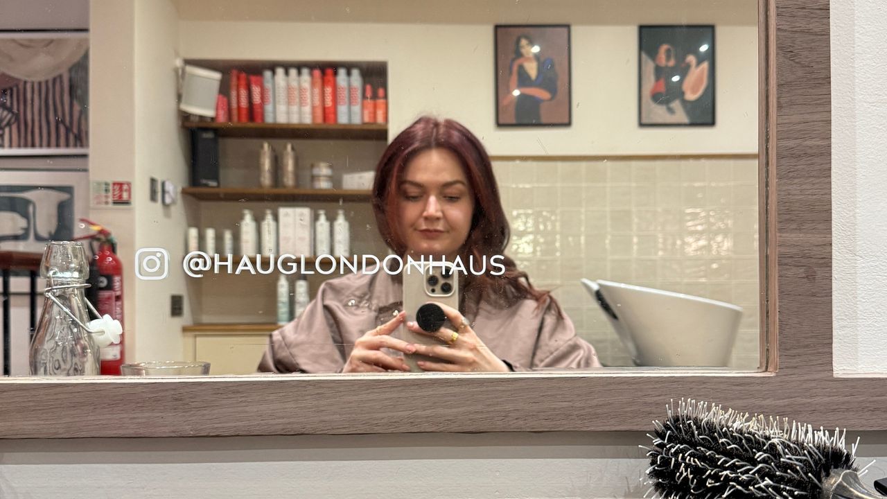 Image of beauty editor Lucy in a hair salon taking a picture of her reflection in the mirror