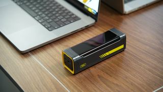 AOHi Starship 240W Power Bank on desk next to laptop