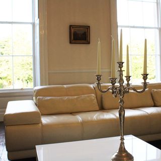 living room with cream sofa and candle stand