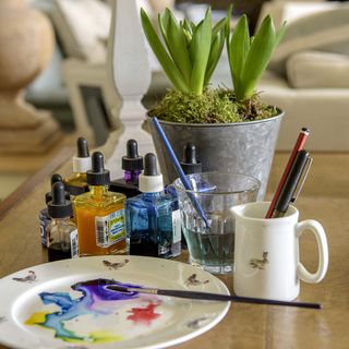 table with plant and painting materials