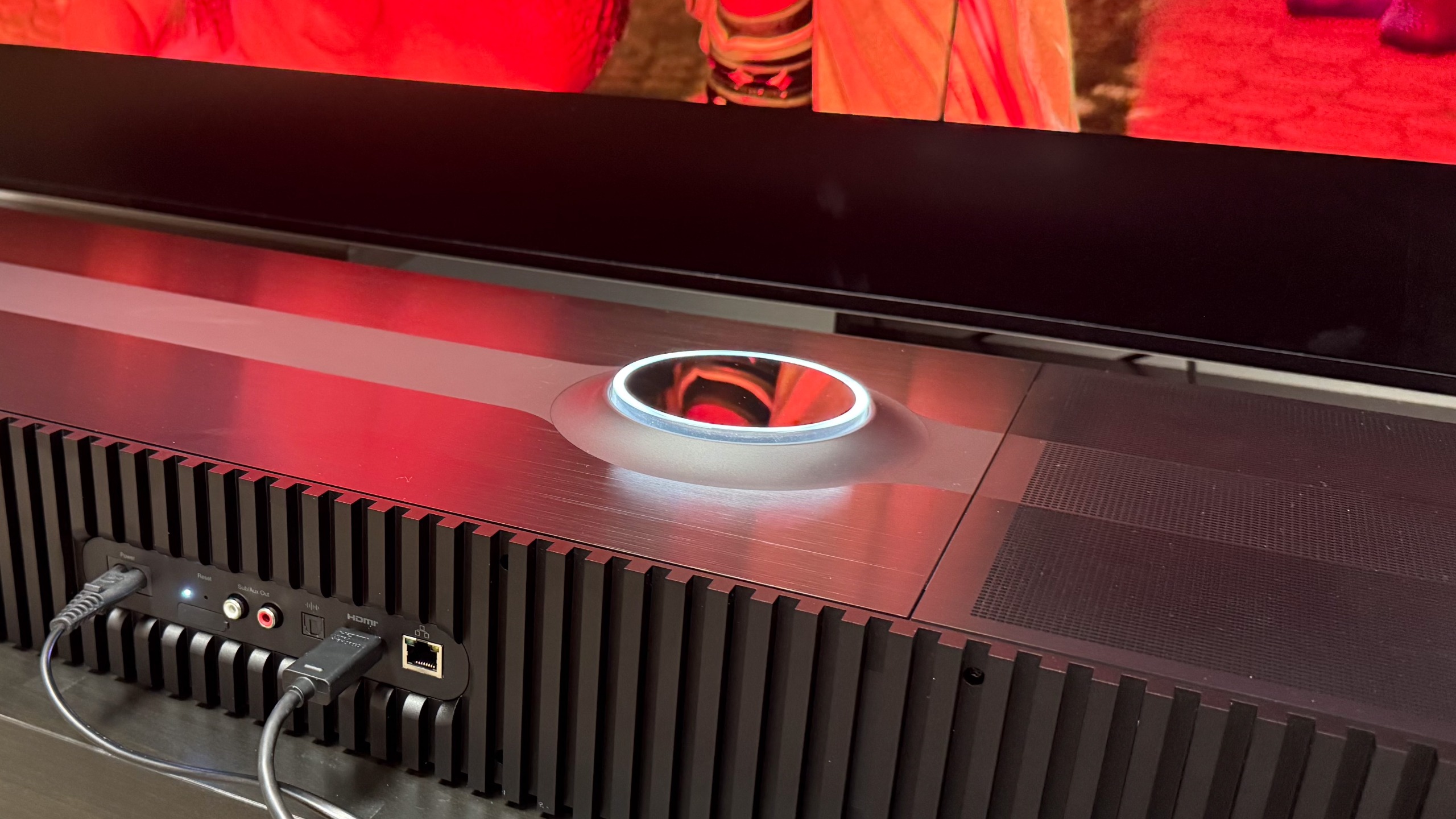 The Focal Mu-so Hekla from behind showing its ports and the movie Elio reflected in its surface and dial.