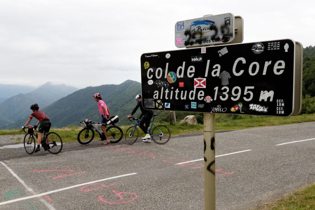 Australian cyclist Lachlan Morton C and amateur cyclists take a break during the 13th day of his solo alternative Tour de France cycling race at the Col de la Core near Bethmale on July 8 2021 Lachlan Morton is riding every kilometer of the Tour de France plus the distances between race starts and finishes solo He stops at cafes for his food and sleep under the stars at night Morton is racing to raise money for World Bicycle Relief Photo by VALENTINE CHAPUIS AFP Photo by VALENTINE CHAPUISAFP via Getty Images