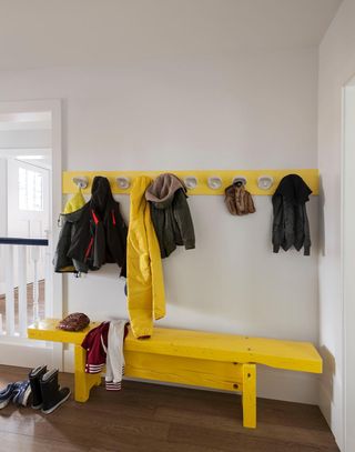 Hallway with yellow bench and coat rack