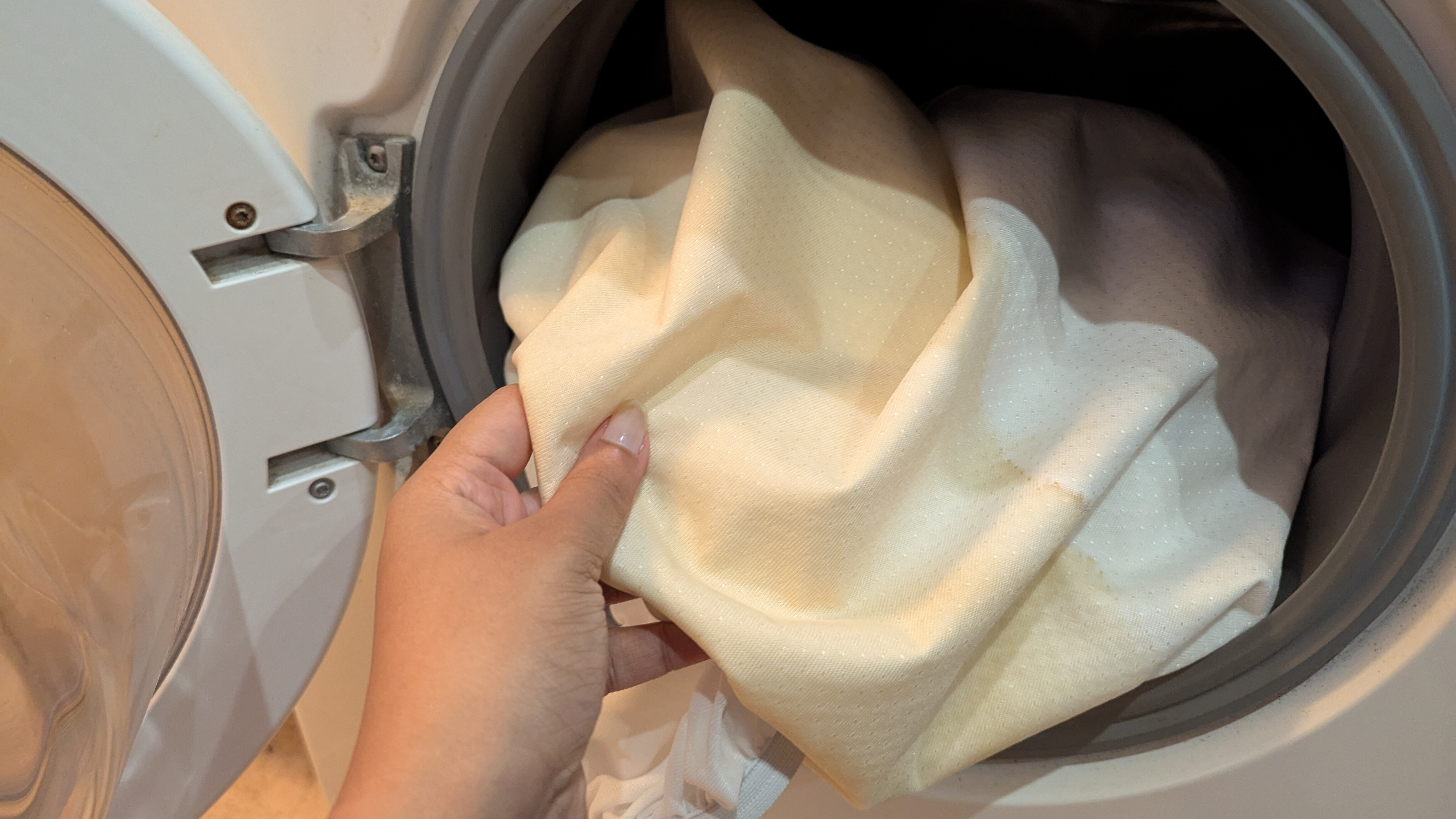 Stained mattress protector inside a washing machine