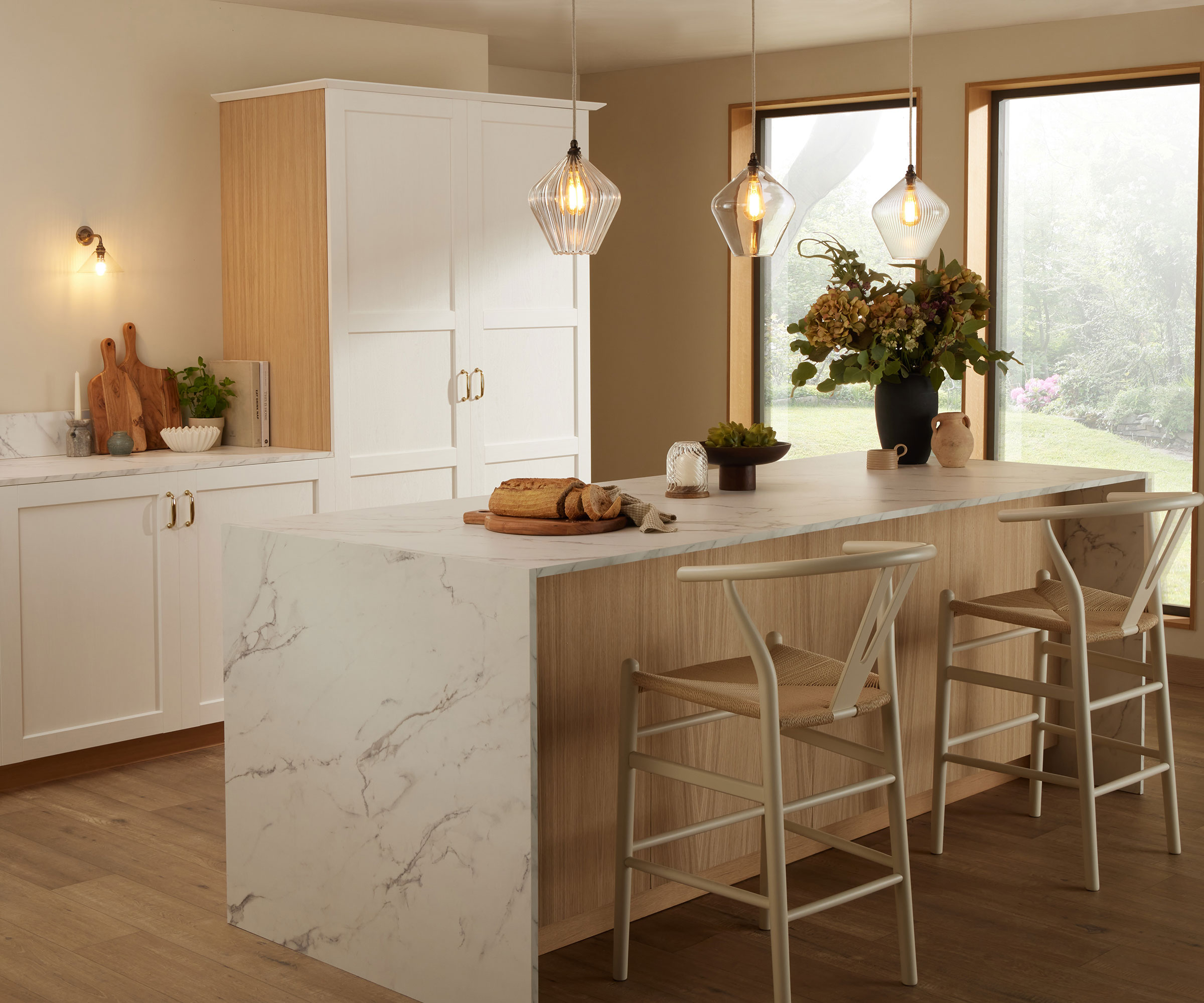 white kitchen with pendant lights over kitchen island