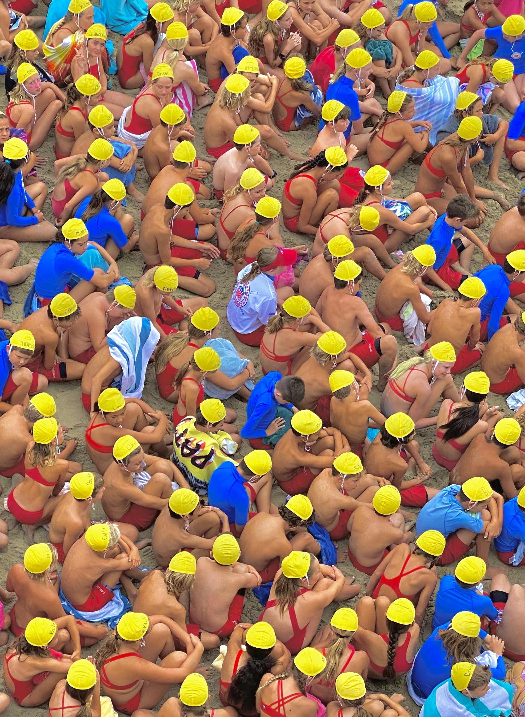 A group of people wearing yellow bathing caps