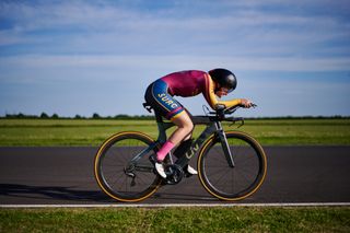A woman riding a time trial bike at Castle Combe motor circuit