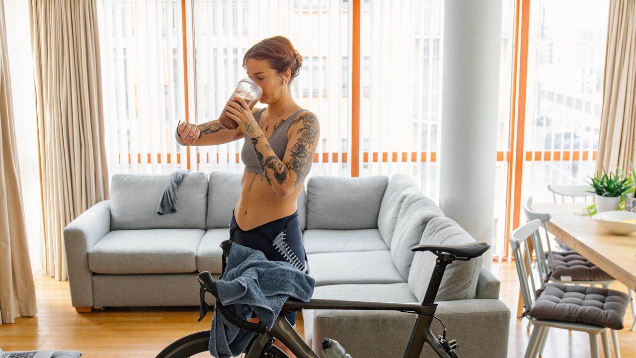 Woman drinking a protein shake after exercising at home