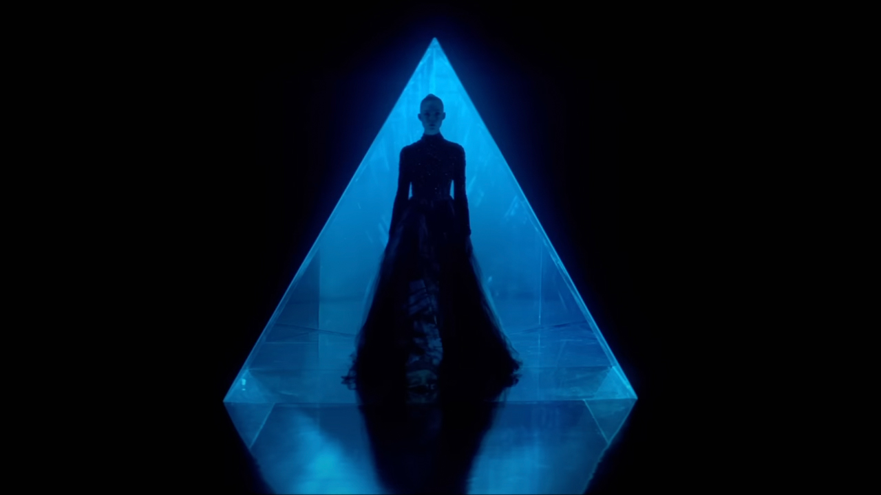 Stunning cinematography of Elle Fanning posing inside of a triangle and wearing a flowing gown in The Neon Demon.