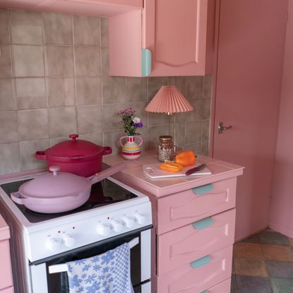 pink painted kitchen with hob and pans