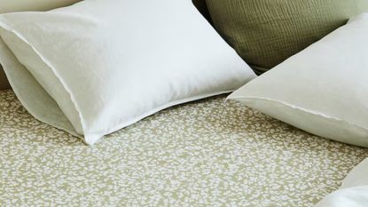 H&M Home botanical patterned fitted sheet in sage styled with white and coordinating sage pillows