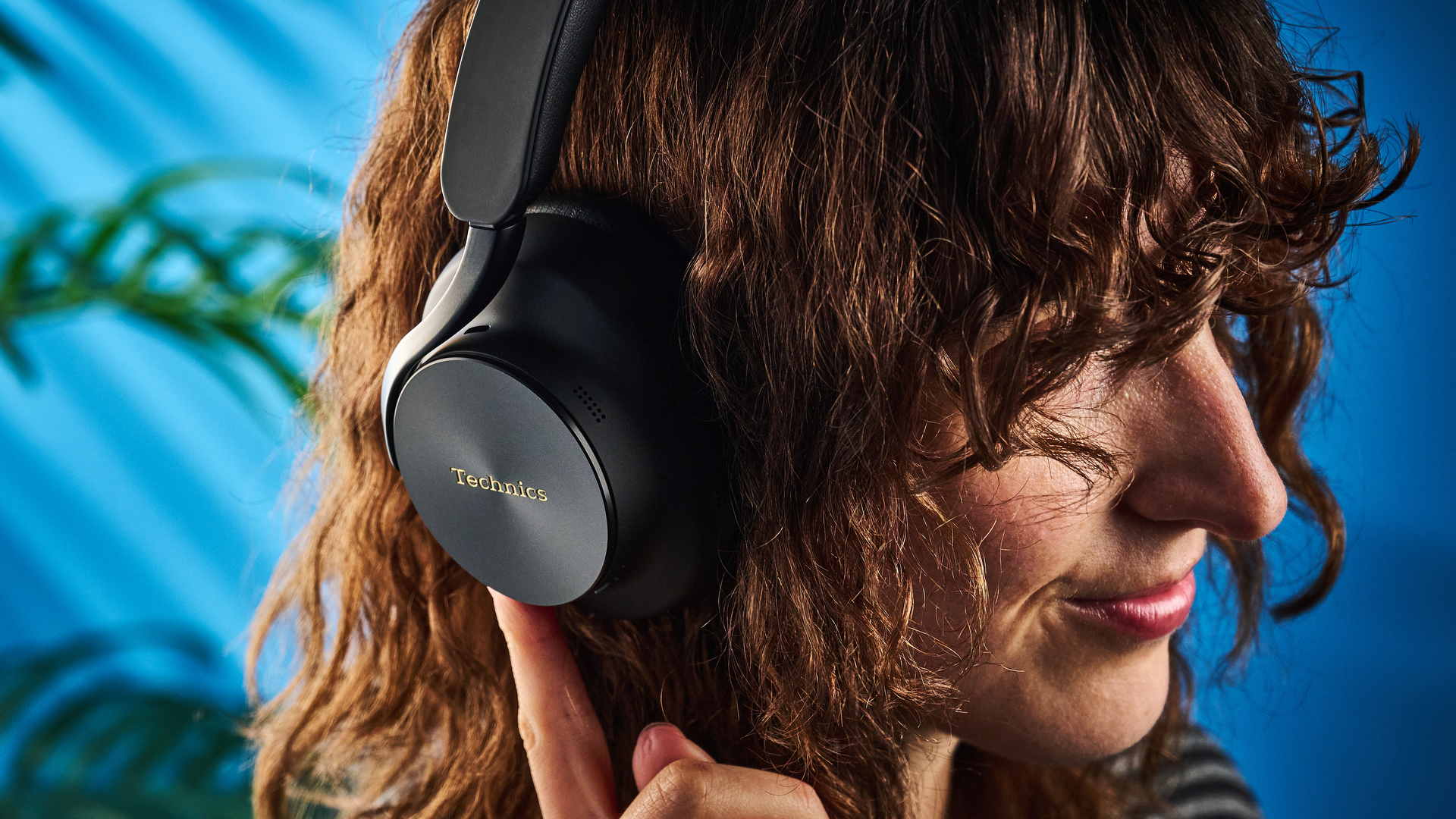 the technics eah-a1000 headphones with a gold technics logo photographed against a blue background