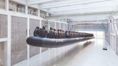 Metal artwork by Ai Weiwei of an enormous lifeboat with lots of people in lifejackets on board