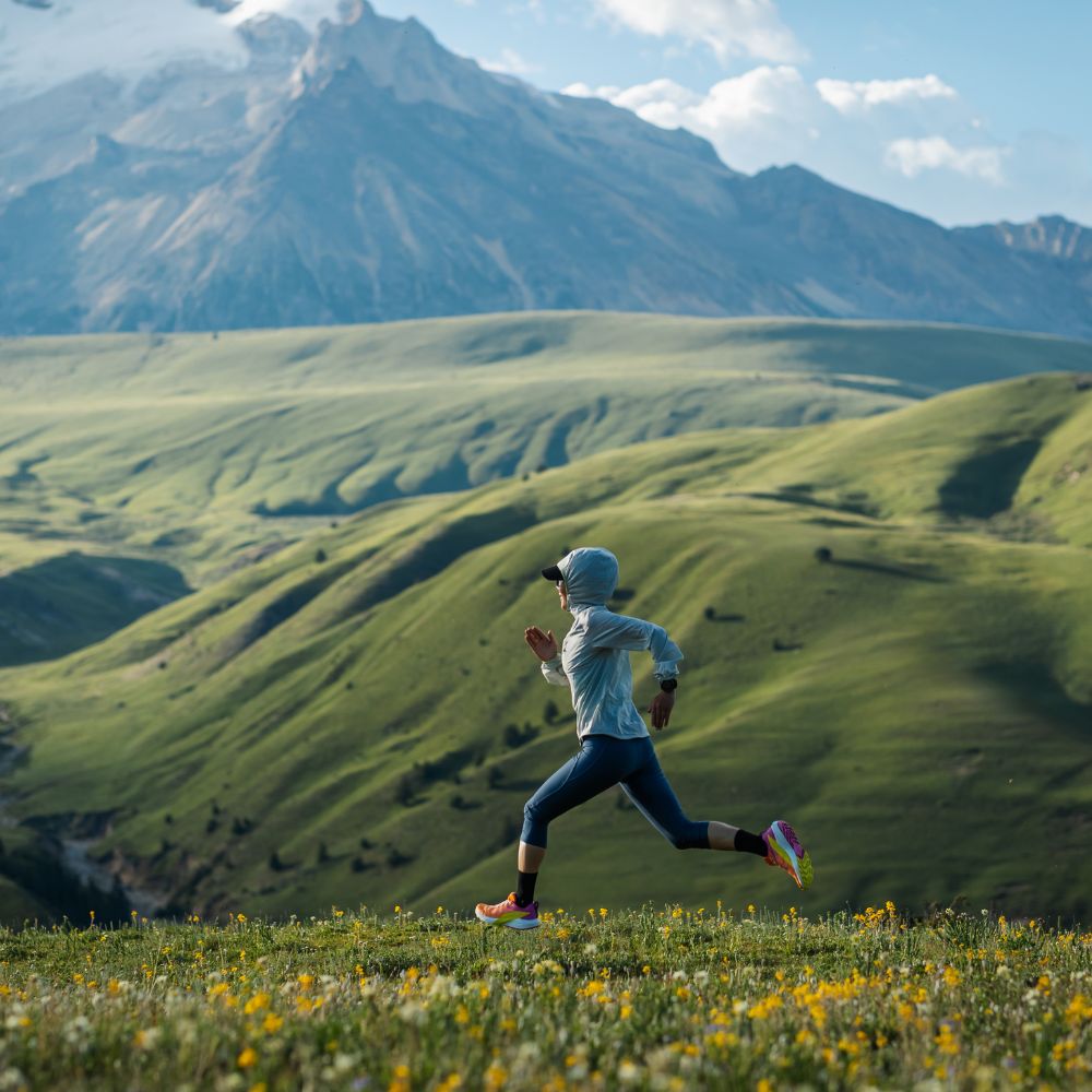 A woman trail running in the mountains.