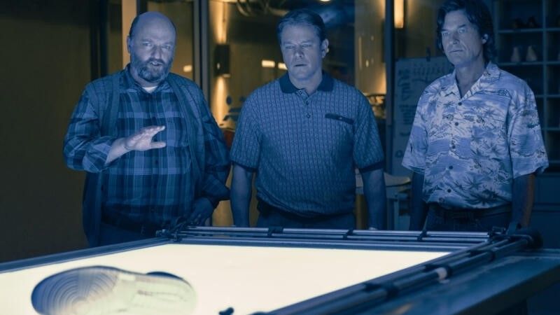 Matthew Maher, Matt Damon and Jason Bateman look at a sneaker in AIR