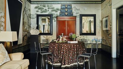 a large open living dining room in a new york apartment with mural wallpaper, vintage decor, round table and chairs with dark floors