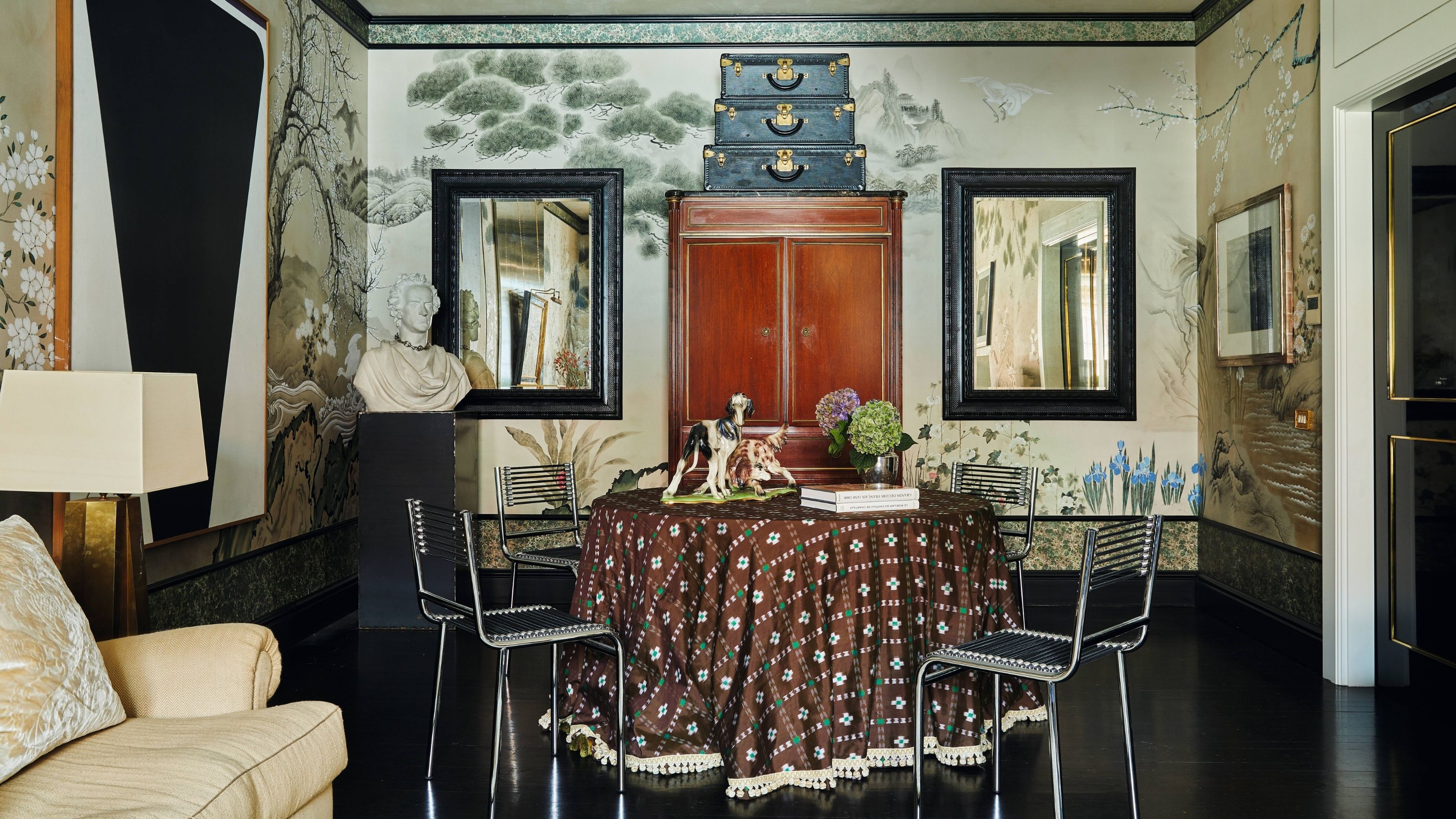 a large open living dining room in a new york apartment with mural wallpaper, vintage decor, round table and chairs with dark floors