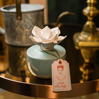 ceramic diffuser on golden plate with tag card