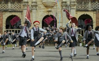 Cast of Matilda the Musical kids dancing in school uniforms
