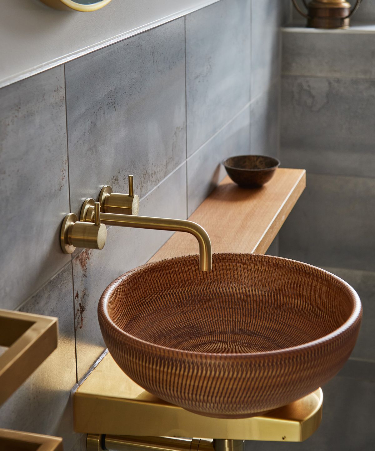 An ornate copper sink with brass taps in a small downstairs WC