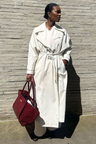 @nlmarilyn in white trench coat and red bag