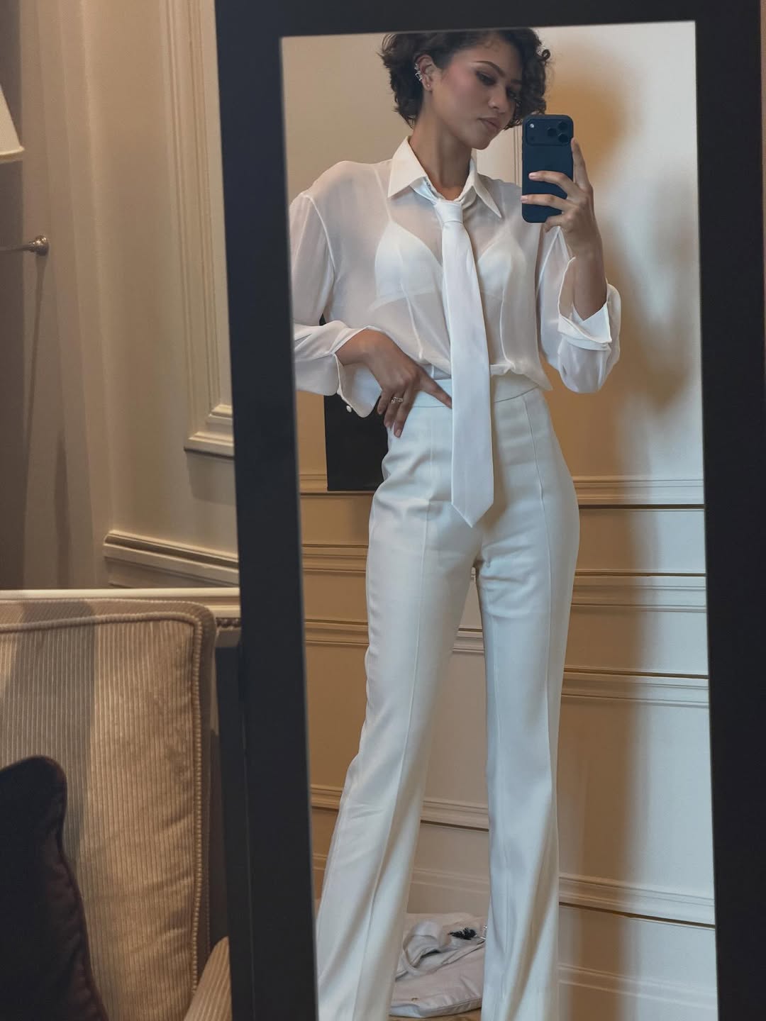 Zendaya posed in all bridal white, beginning with a sheer button-down, a peekaboo bra, and the neck tie trend