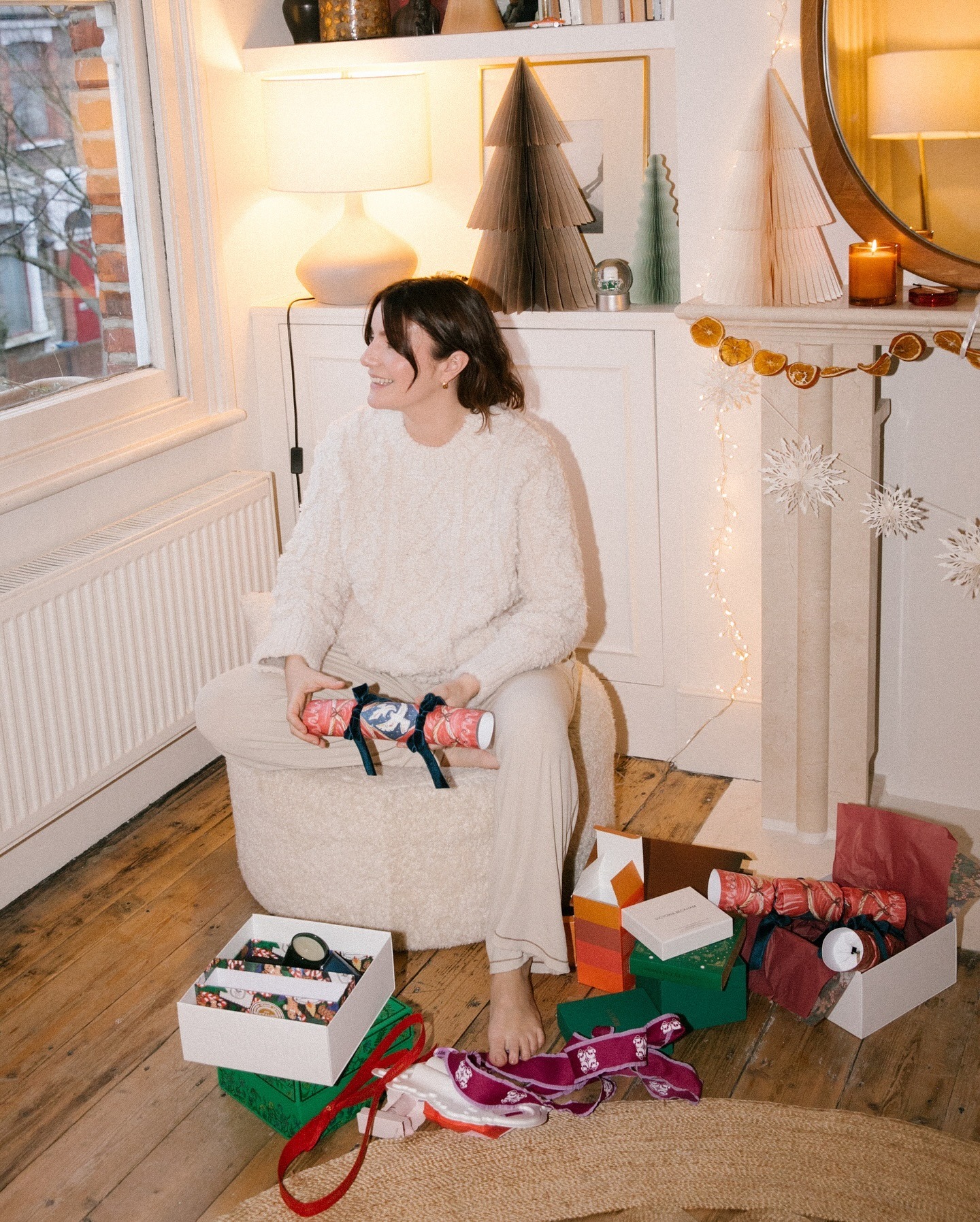 A woman on Christmas Day opening presents in the living room