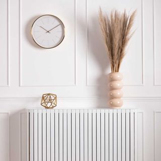 room with radiator cream vase and wall watch
