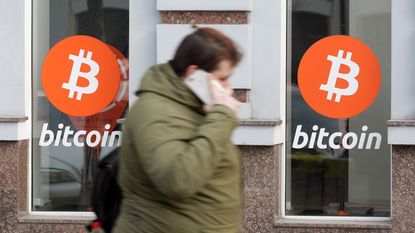 Woman walking past a bitcoin cryptocurrency exchange