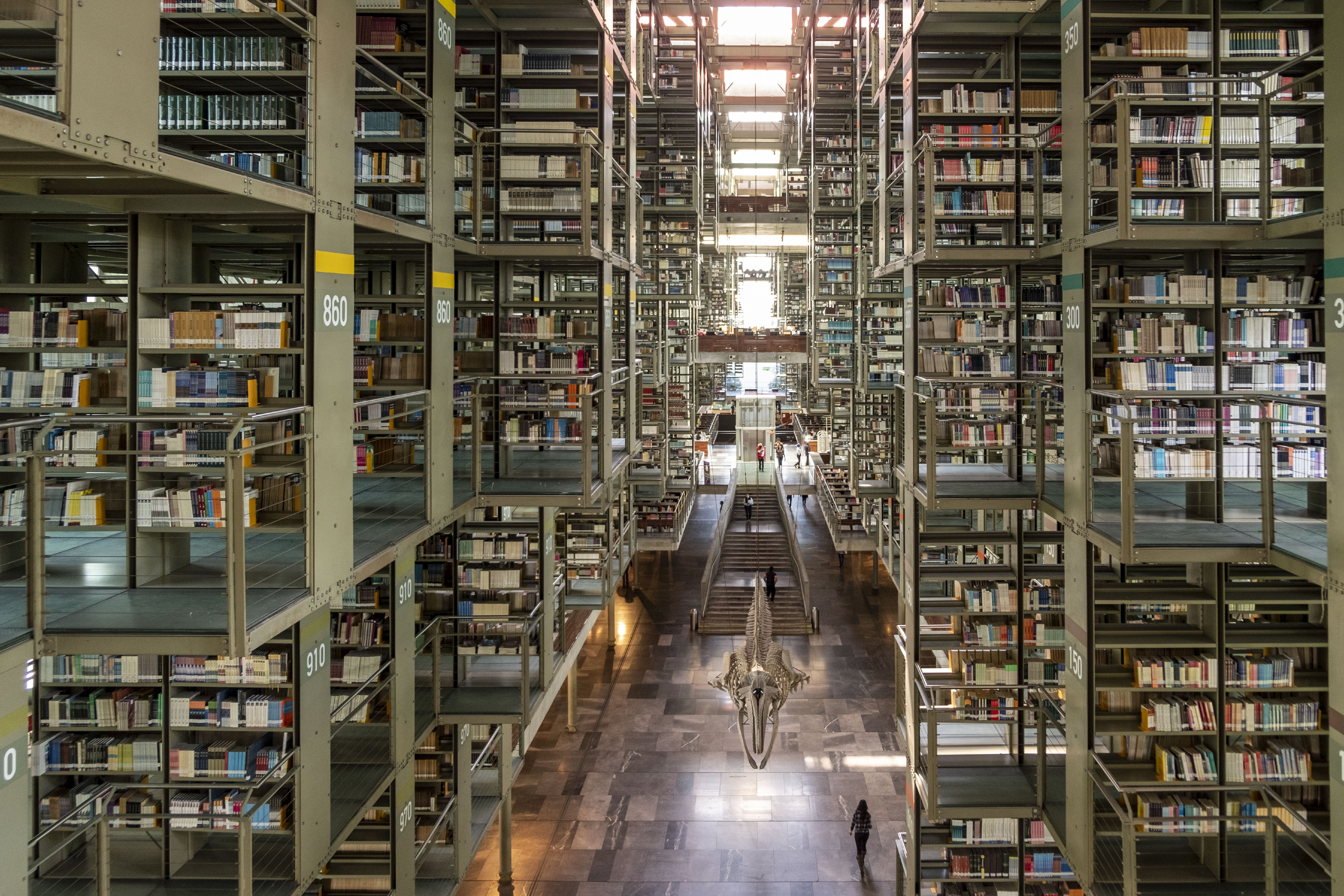 A meticulously preserved, color-coded modernist public library features pale green architectural structures brought to life by colorful volumes and furniture.