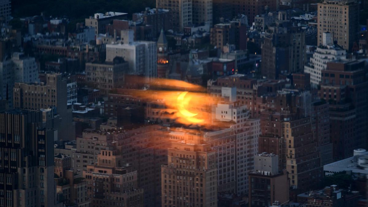 The partial solar eclipse of June 10, 2021, seen reflected in glass from a Manhattan skyscraper by Ed Jones.
