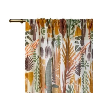 A colorful curtain panel with orange, purple and green leaves, on a metal rod