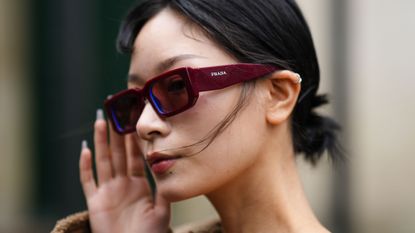 a model wears a pair of prada sunglasses during fashion week
