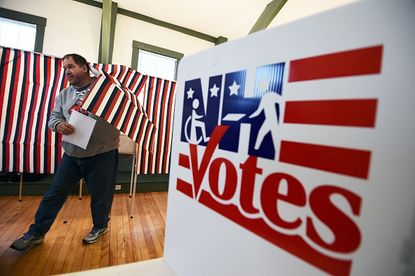 A man exits a voting booth in New Hampshire.