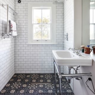 Wet room with white metro tiled walls and patterned floor tiles