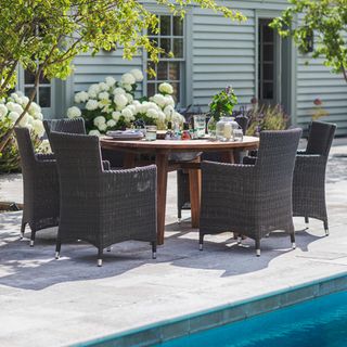outdoor dining table and chair beside swimming pool