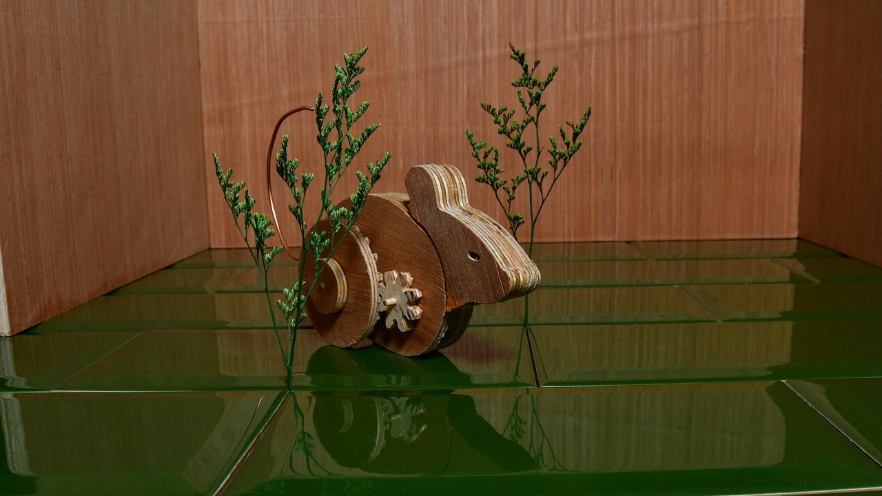 Wooden mechanical mouse in empty room with green tile in Ealu.