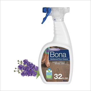 White spray bottle with blue trigger and bunch of purple lavender on white bakground