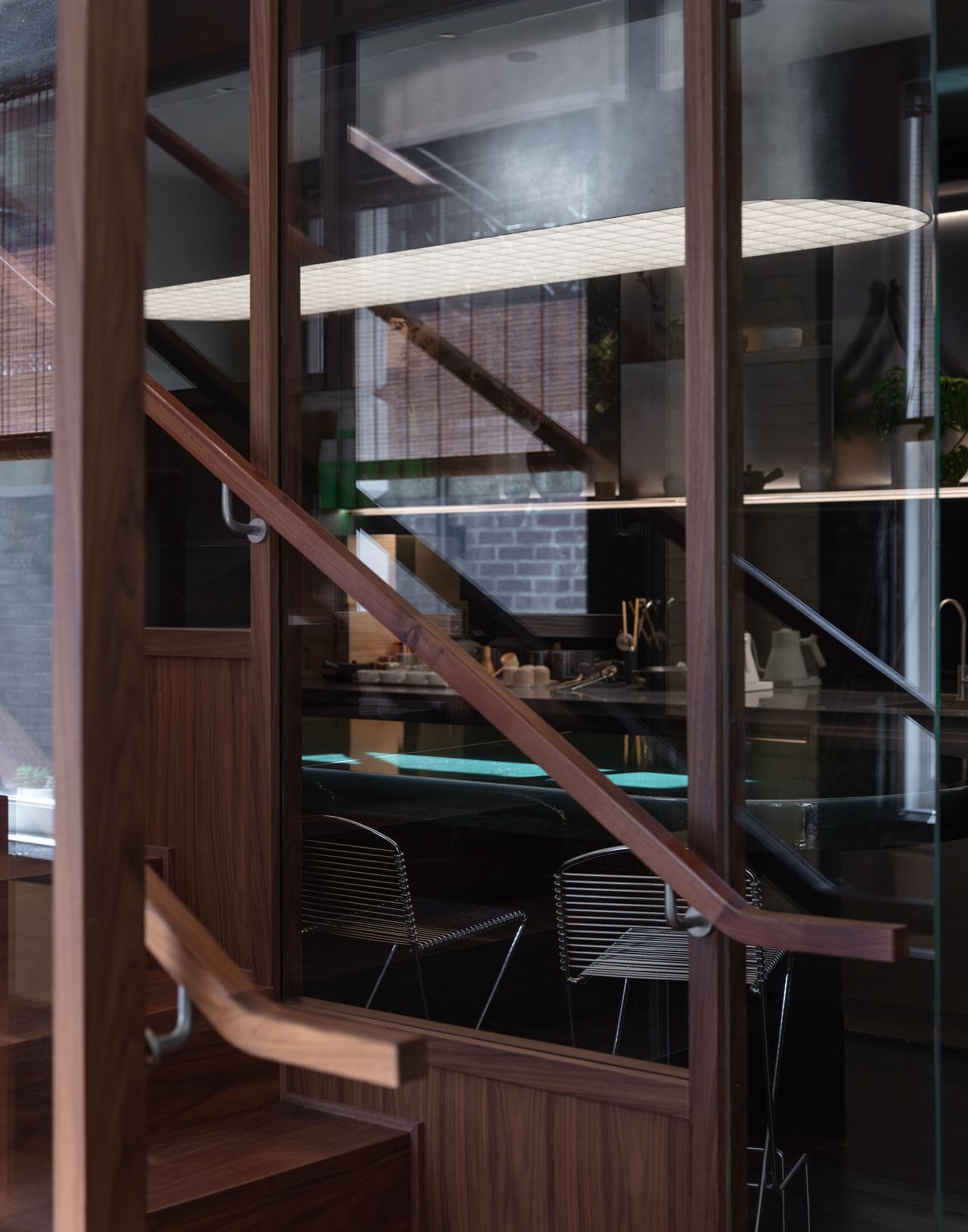 A futuristic matcha cafe features Japandi interiors punctuated by wood, chrome, or emerald green tones, and a sci-fi-esque bar setup with dripping water bottles and lights.