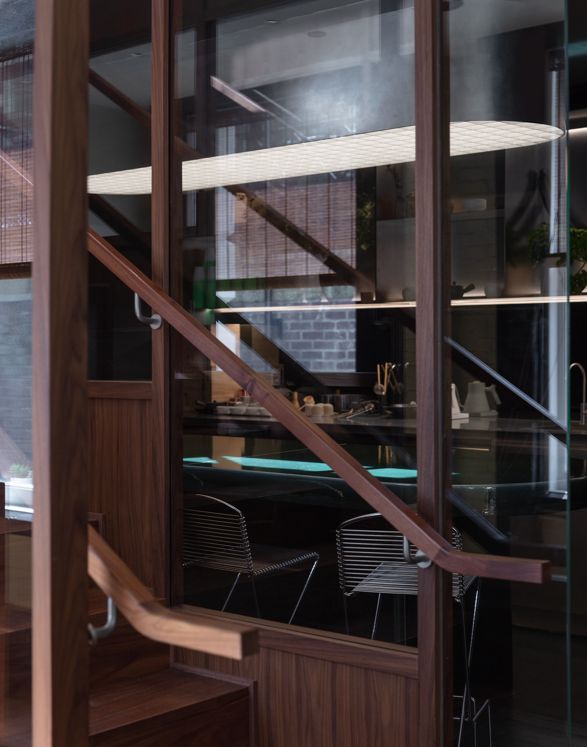 A futuristic matcha cafe features Japandi interiors punctuated by wood, chrome, or emerald green tones, and a sci-fi-esque bar setup with dripping water bottles and lights.