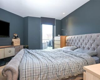 bedroom with tv on blue wall and luxury bed with pillows